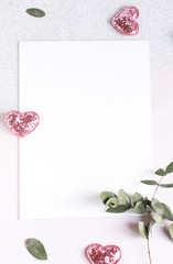 Background with copy space blank on white table with glitter heart, eucalyptus branch, flowers and...