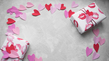 Pink red and lilac hearts and Valentine's Day gifts with kissing lips on light textural background.