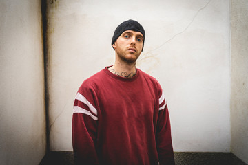 portrait of young rapper posing in front of a white wall