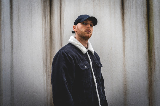 Portrait Of Young Rapper Posing In Front Of A White Wall