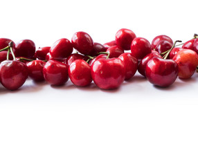 Fresh cherries scattered on white. Cherries on a white background. Fresh cherry. Cherry fruit. Cherries with copy space for text. Background of cherries.Sprinkled cherry on white background.