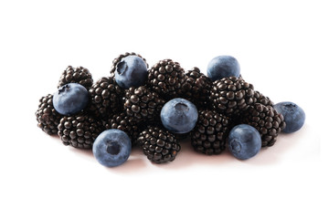 Black and blue berries isolated on a white. Top view. Ripe blackberries and blueberries on white...