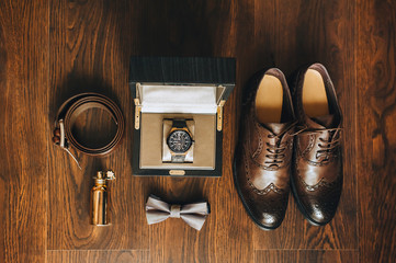 Wedding and gentlemanly man's set: leather shoes, belt, bow tie, perfume, watch. The morning of the groom. Business, wealth, details. Photography and concept.