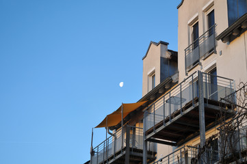 a modern house with balconies in morning sun