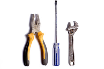 Pliers, screwdriver and adjustable wrench on a white background