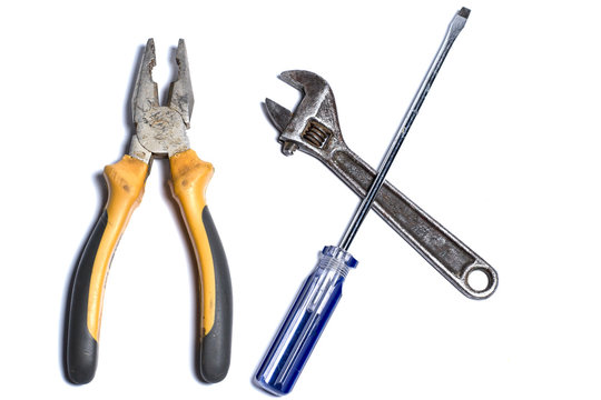 Pliers, Screwdriver And Adjustable Wrench On A White Background