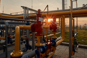 Gas industry. Pipeline system at gas processing plant illuminated by the rays of the rising sun