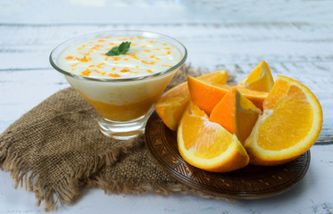  Delicious yogurt with orange smoothie on a white wooden table. The concept of healthy desserts.