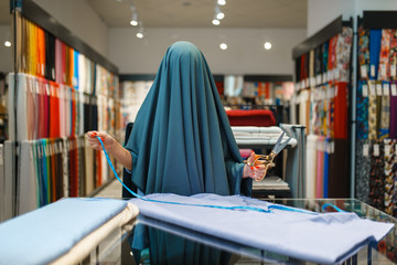Woman wrapped in fabric, textile store