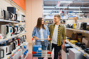 Young couple with cart in electronics store