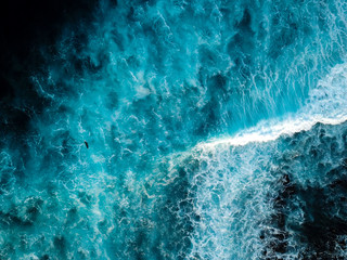 Bird eye view of surfer in Lanzarote paddling into wave