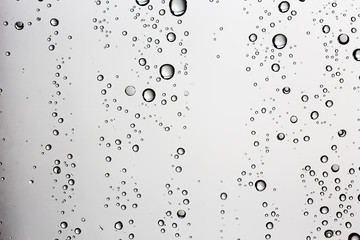 white isolated background water drops on the glass / wet window glass with splashes and drops of water and lime, texture autumn background