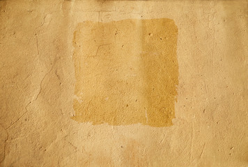 Background. Wet square stain on yellow wall. Light brown sand. Place for text