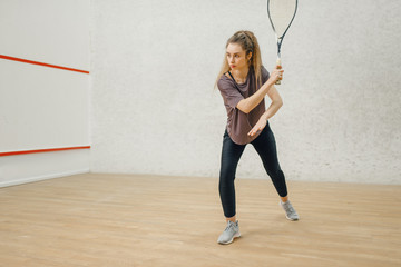 Female player with squash racket in action