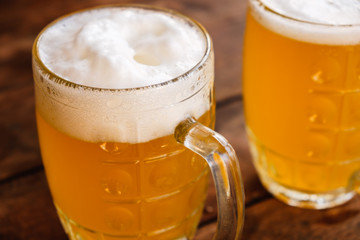 Close-up two cold beers with foam and drops.