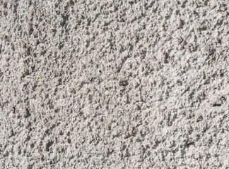 A rough gray cement wall, close-up.