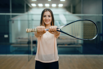 Female player shows squash racket on court