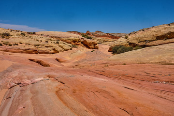 Dry gully in the Nevada desert surrounded by the colorful pink lined rocks