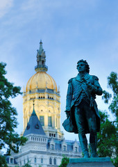 A Statute of Israel Putnam, an officer in the American Revolution. stands at the Connecticut State Capitol in Hartford, Connecticut after sunset.