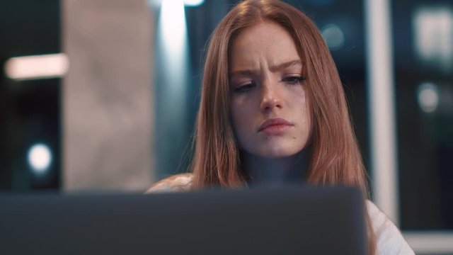 Thoughtful concerned caucasian young woman works on laptop computer think solving problem at modern apartment serious woman search for inspiration make decision feel lack of ideas close up freelancer