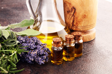 Fresh herbs from the garden and the different types of oils for massage and aromatherapy on table...