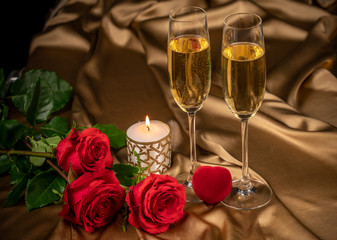 Valentine's day card, two glasses of champagne on a gold background red roses and a red heart, a lighted candle