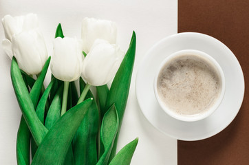 Beautiful bouquet of white tulip gentian flowers, cup with coffee and brown napkin on a white background. Copyspace, gift for the bride girl. Declaration of love.