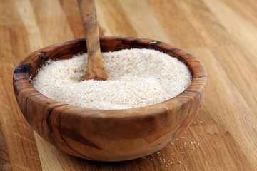 Portion of Psyllium Seeds on rustic dark background. Psyllium seed husks on wood
