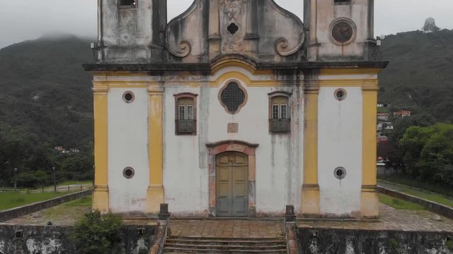Aerial ascend from the stairs to details of the old Saint Francis of Paola church facade on a hilltop in colonial mining city Ouro Preto part of the gold route in the state of Minas Gerais in Brazil