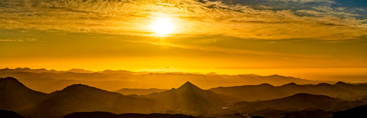 Panoramic Sunset over Silhouetted Mountains