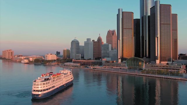 Aerial: Ferry boat on the Detroit river at sunrise. In the background is the city of Detroit, Michigan, USA
