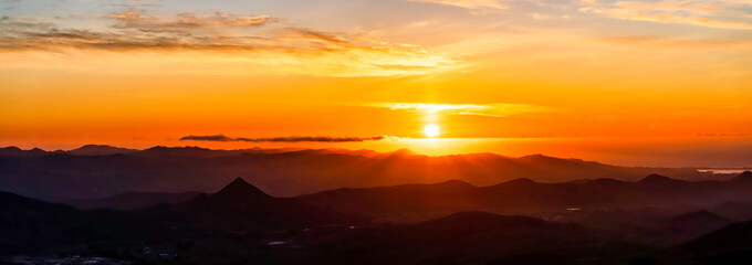 Panorama of Sunset over Silhouetted Mountains