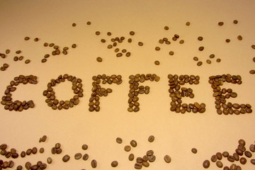 Coffee grains on a light backround.   inscription of coffee.