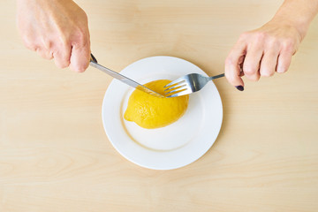An elderly woman is eating a lemon. She is on a diet. She is looking for beauty and weight loss