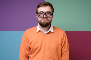 Unhappy man with a beard, put on three pairs of glasses and made a very sad grimace. Negative...