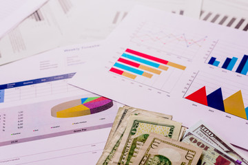 Purchase and investment planning analyzing data in graphs and charts, defocused background.