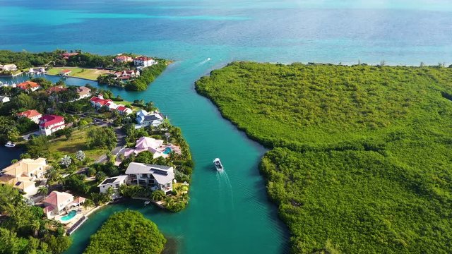 aerial drone footage of the island of grand cayman in the cayman islands in the tropical clear blue waters of the caribbean sea showing west bay, north sound, seven mile beach and yachts