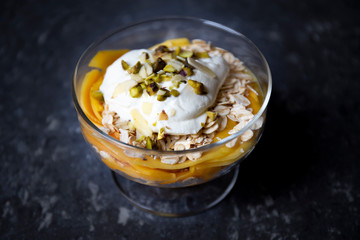 Mango with yogurt, muesli cereals and pistachio