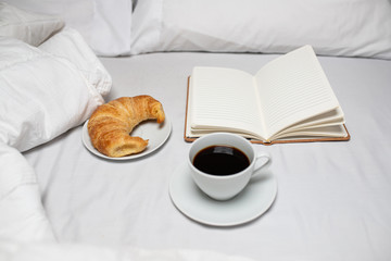 Breakfast in bed with an open notebook