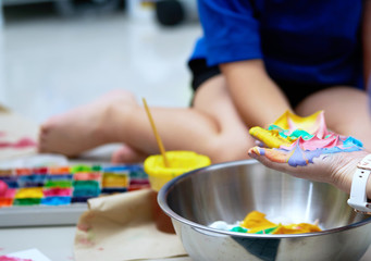 hands and kid working on slime making with colorful ingredient