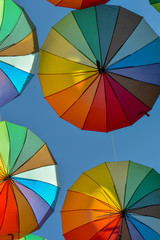 colorful umbrella arrangement as background against blue sky