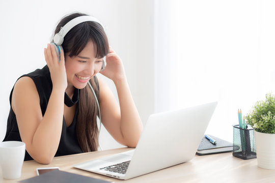 Beautiful young asian woman wear headphone smiling say hello using chat video call on laptop computer, girl relax enjoy listening music online, education learning, communication and lifestyle concept.