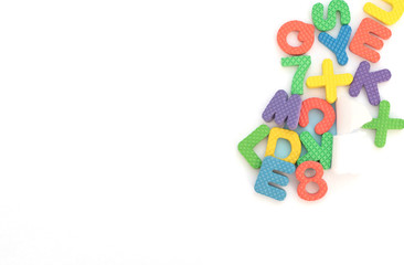 Hole with multi-colored soft English letters and numbers on white background with copy space. Kid's set for teaching reading and counting. Back to school. Flat lay style, top view with copy space.