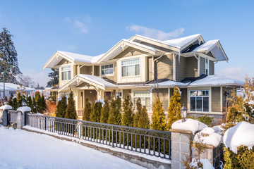 A perfect neighbourhood. Houses in suburb at Winter in the north America. Luxury houses covered...