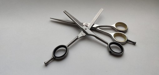 Hairdressing scissors lie on top of each other, one open, side view