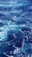 Sea water, white sea foam, water texture, pacific ocean. natural background. foam composition in the dark ocean water