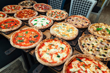 Lots of pizzas on wooden background. Pizza party