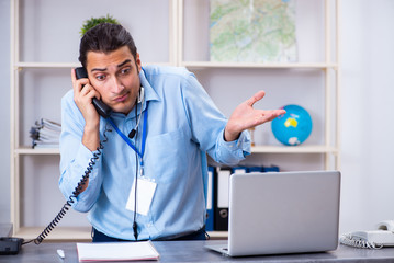 Young male travel agent working in the office
