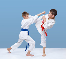 Two karate athletes are beating blows feet and punches