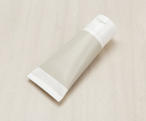 Blank white plastic cream tube or gel product mockup template on wooden background.